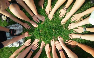 Dużo rąk w kole razem na trawie